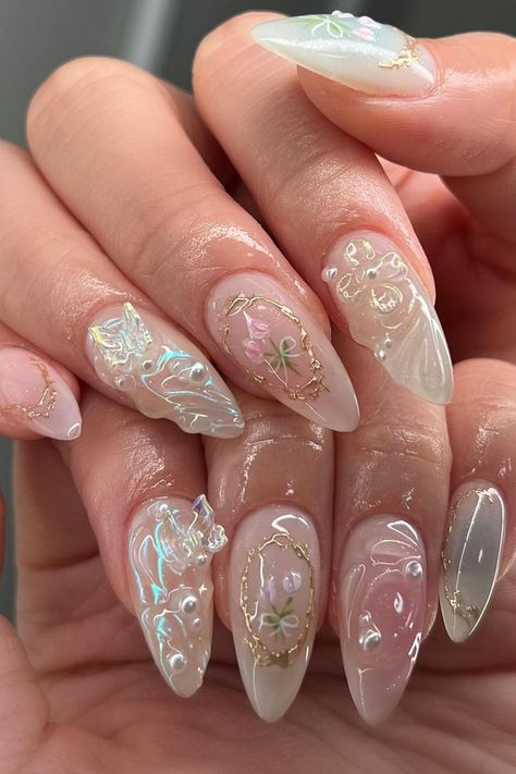 These almond-shaped nails exude a subtle elegance with a sheer pink base. The look is enhanced with accents of gold flake borders, delicate white floral patterns, and small, strategically placed pearls. The nails also play with texture and depth as some feature an encapsulated petal design, giving an ethereal 3D effect. An exquisite touch of class for any occasion.  // Photo Credit: Instagram @amys.clients White Douyin Nails, Press On Nails Tips, Douyin Nails, Long Almond, Nagel Tips, Nails Tips, Black Y2k, Nail Forms, Nail Length