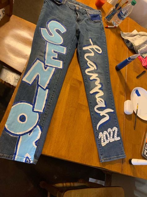 15 Cutest Senior Jeans Ideas We're Obsessing Over Right Now Senior Jeans Ideas, Homecoming Jeans Ideas, School Spirit Outfit, Senior Painted Jeans, Senior Year Diy, Senior Year Things, Senior Week, Senior Class Shirts, Senior Year Fun