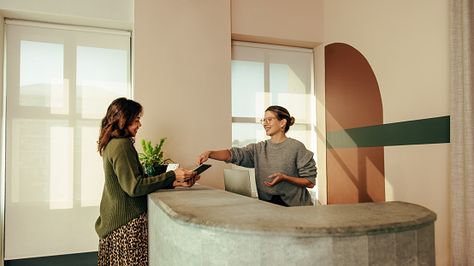 Carefree receptionist assisting a woman with signing in to an office Modern Lobby, Shot List, Photo Reference, Kiosk, Check In, Lobby, A Woman, Ipad