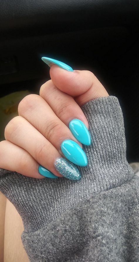 blue and glitter almond shaped nails. simple ocean inspired. Sea Blue Nails Aqua, Cute Spring Break Nails Almond, Ocean Blue Almond Nails, Teal Nails Almond Shape, Teal Nails With Rhinestones, Ocean Blue Nails Acrylic, Ocean Blue Nails Summer, Glitter Almond Shaped Nails, Almond Shaped Nails Designs Summer