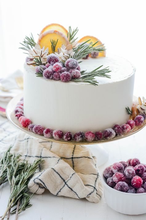 Orange Layer Cake on cake pedestal with back lighting. White Cake With Cranberry Filling And Orange Buttercream, White Cake With Orange Slices, Winter Citrus Cake, Iced Christmas Cake, Christmas Cakes Buttercream, December Cake Ideas, Cake With Dried Oranges, Beautiful Christmas Cakes, Christmas Orange Cake