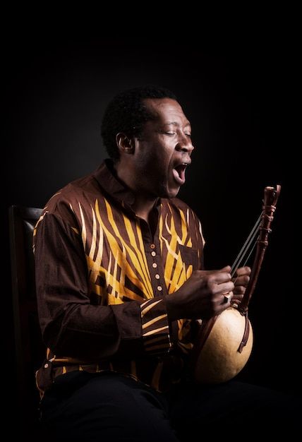 African black man with ethnic musical in... | Premium Photo #Freepik #photo #music-man #music-artist #musician #play-guitar Photo Music, Music Man, Play Guitar, Music Artist, Black Man, Musical Instrument, Premium Photo, Musical Instruments, Black Men