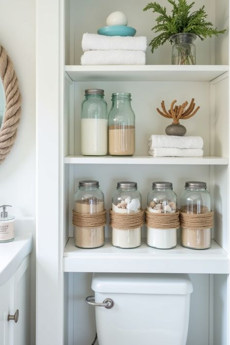 Coastal bathroom shelving with organized beach-themed accessories Coast Bathroom Ideas, Coastal Bathroom Accessories, Seaside Bathroom Ideas, Blue Coastal Bathroom, Coastal Blue Bathroom, Sea Themed Bathroom, Wooden Bathmat, Seaside Bathroom, Diy Nautical Decor