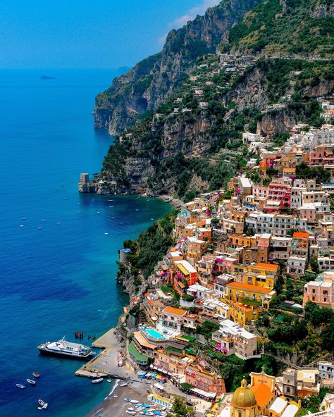 "When in Positano, which is located along the Amalfi Coast of Italy, you will be very tempted to spend your entire time meandering along the beach, the storefronts and restaurants. And why not, it is such a beautiful town that you just can't get enough of it.  While I do agree and can confirm that we did spend plenty of time in the core of the town, I wanted to see more and from a different perspective, I wanted to go high up.   With our hiking boots on, we began our trek to get to top of the mountain range that cradles the town.  The hike took a while but the visuals along the hike were fantastic.  With every new elevation and turn, there was a new vista to enjoy.  When we reached about halfway up the mountain, we came upon this location from where I witnessed this view, it was very speci Coast Of Italy, Beautiful Town, Vertical Wall Art, Positano Italy, Italy Photography, Italy Aesthetic, Pretty Landscapes, The Amalfi Coast, Dream Travel Destinations