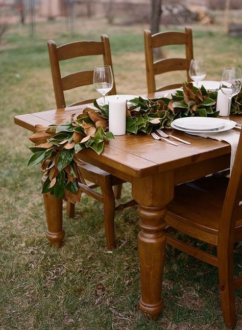 pretty details | magnolia leaves table runner Magnolia Leaves Centerpiece, Woods Party, Autumn Entertaining, Leaf Table Runner, Magnolia Leaf Garland, Magnolia Christmas, Magnolia Garland, Magnolia Leaf, Party Colors