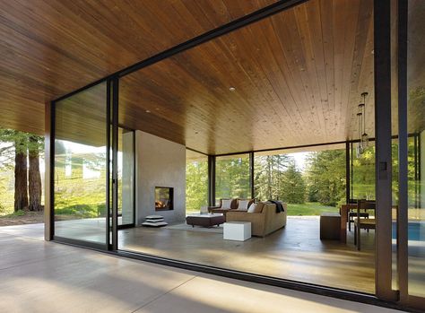 “Creating efficient space is valuable, but for us, rooms that offer visual and spatial continuity with nature are also important,” architect Julie Dowling explains. “When the sliding doors are open, the living room and kitchen double in size.” Modern Glass House, A Modern House, Sliding Glass Doors, Home Stay, Concrete Floor, House Goals, Modern Glass, Glass Doors, Glass House