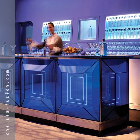 Image: Bombay Sapphire cocktail bar, London. Front of bar: oblong pattern #sandblasted onto #mirror with UV bonded standard #glass in front, backlit with blue light, minimal fixing details. Top of bar: cocktail glass places sandblasted onto colour coated mirror. #architecture Bar Front Ideas, Mirror Architecture, Bar Table Design, Minimal Bar, Cocktails Cart, Bar Counters, Bar Stand, Smoked Mirror, Bombay Sapphire