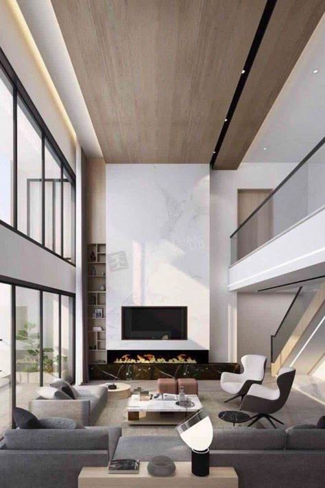 We're obsessed with this living room design. It has unique details and the perfect statement pieces! Find out the Best Interior Designers in New York City in the link below! #newyorkfurniture #newyorkart #newyorkarchitecture #newyorkproperty #newyorkdesigner Double Height Fireplace Modern, Double Volume Living, High Ceiling Tv Wall Interior Design, Wood Accent Wall High Ceiling, Modern Fireplace High Ceiling, Double Height Living Room Fireplace, Fireplace Double Height, Double Volume Ceiling Design, Double Hight Tv Wall Design