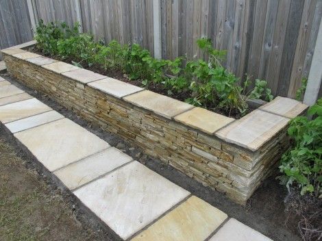 Raised stone garden bed Stone Raised Garden Beds Along Fence, Stone Planters Ideas, Paver Garden Bed, Stone Raised Garden Beds, Stone Planter Boxes, Garden Digging Tools, Stone Raised Beds, Rose Bed, Garden Pavers