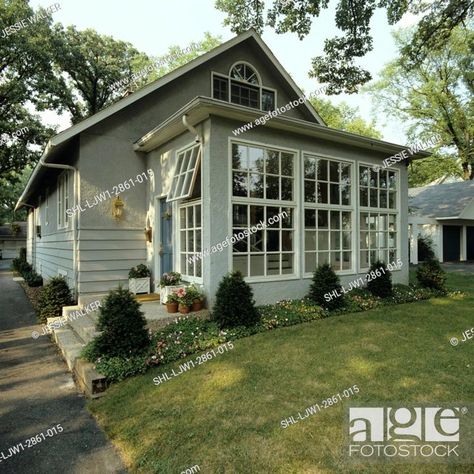 SUNROOMS: Front of small grey stucco bungalow, addition of sunroom, Stock Photo, Picture And Rights Managed Image. Pic. SHL-LJW1-2861-015 | agefotostock Front Of House Sunroom, Front Sunroom Entrance, Sunroom Front Of House, 3 Season Room Addition, Stucco Bungalow, Entryway Exterior, Bungalow Addition, Grey Stucco, Border Gardens