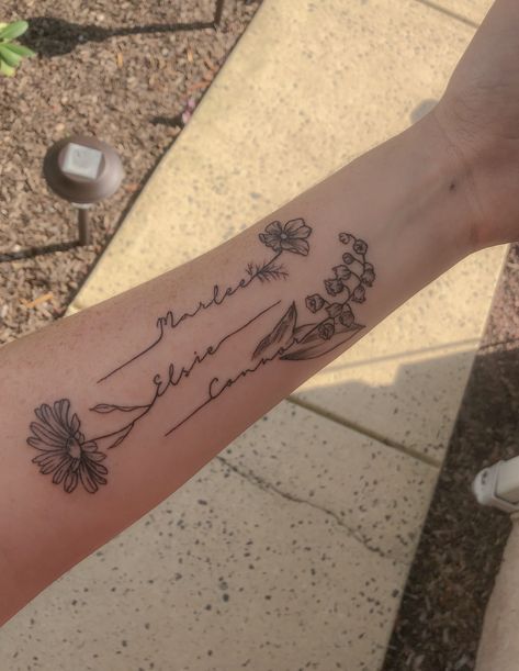 Names with flowers forearm tattoo. Lily of the valley tattoo, daisy tattoo, cosmos tattoo #tattoo #flowertattoos #tattooideas Tattoo Ideas With Names, Tato Nama, Name Flower Tattoo, Cosmos Tattoo, Daisy Tattoo Designs, Kid Name Tattoo, Flower Tattoo Ideas, Tattoos With Kids Names, Daisy Tattoo