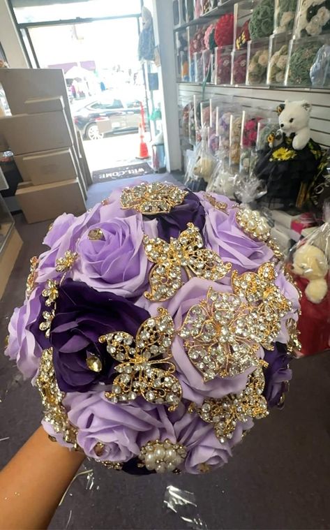 This silk flower bouquet is designed specifically for Quinceañeras, adding a touch of elegance and tradition to the special celebration. Crafted with high-quality silk flowers, it will beautifully accentuate the attire of the Quinceañera and serve as a lasting keepsake. Purple And Gold Flowers, Quinceanera Ramo, Gold Wedding Bouquets, Purple Quinceanera, Quinceanera Bouquet, Silk Flower Bouquet, Purple And Gold Wedding, Purple Bouquets, Quince Hairstyles With Crown