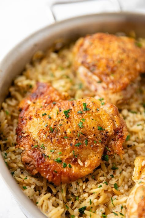 One Pot Chicken and Rice Pilaf - crispy chicken thighs with garlicky homemade rice pilaf. Chicken And Rice Pilaf Recipes, Chicken And Rice Pilaf, Homemade Rice Pilaf, Chicken Rice And Peas, One Pot Chicken And Rice, Crispy Chicken Thighs, Viral Recipes, Amazing Chicken, Popular Dinner Recipes