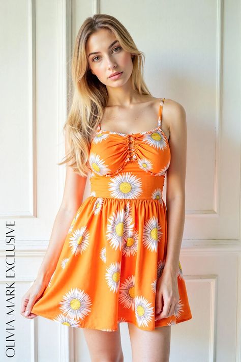 Its vibrant orange canvas is adorned with a cheerful pattern of daisies, their petals a pristine white against the sunny yellow centers. The fitted bodice, with its delicate lace-up detail, accentuates the silhouette, while the flared skirt flows with movement, creating an ethereal dance of fabric. This dress is not just clothing; it's an embodiment of joy, a celebration of the simple pleasures that make life bright. Sunny Yellow, Floral Sundress, Vibrant Orange, Simple Pleasures, Flared Skirt, Fitted Bodice, Olivia Mark, Flare Skirt, Sundress