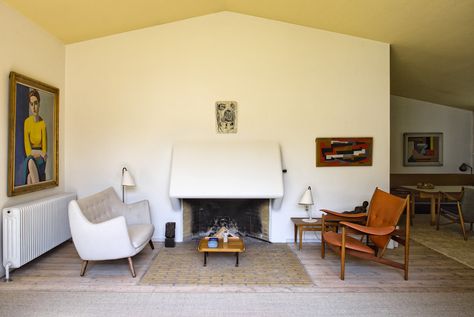 Vilhelm Lundstrom portrait of Juhl’s wife, Hanne Wilhelm Hansen, hangs above Juhl's Poet sofa (1941). The sofa faces one of Juhl's most recognizable designs, the 1949 Chieftain chair. The white brick hearth extends into the room to resemble an area rug. Finn Juhl House, Chieftain Chair, Brick Hearth, Modern Room Divider, Finn Juhl, Hans Wegner, White Brick, Scandinavian Interior, Furniture Design Modern