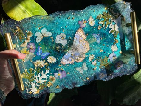 Handmade resin tray with fake butterflies, glitter and pressed flowers. Food safe so feel free to use for charcuterie! Handwashing only. Resin Tray Ideas, Fake Butterflies, Resin Cheese Board, Resin Charcuterie Board, Resin Inspiration, Resin Trays, Crafting Business, Girl Apartment, Handmade Ceramic Planters