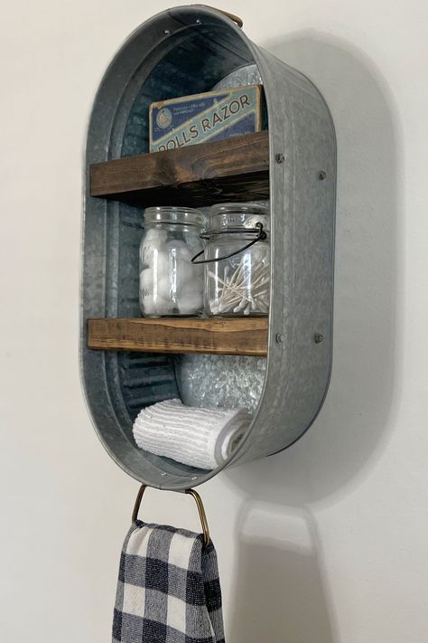 Description:  Add some rustic charm to your home with this Galvanized Metal Wash Tub Wall Shelf.  This Metal rustic shelf is the perfect addition to any room, bathrooms, kitchens, laundry rooms and more. Hang your favorite hand towel from the bottom ring.  Galvanized Metal Tub - Arrives Fully Assembled and Ready to Hang - Hardware Included.    Perfect Size to Hold Small Accessories, i.e. Hand Towels, Soaps, Cotton Swabs, Coffee Mugs,  or Cute Decor. The handle on the bottom of the washtub is per Ny Bathroom, Metal Wash Tub, Lodge Bathroom, Farmhouse Bathroom Accessories, Livestock Barn, Rustic Metal Decor, Shelf Vintage, Farmhouse Shelf, Metal Tub