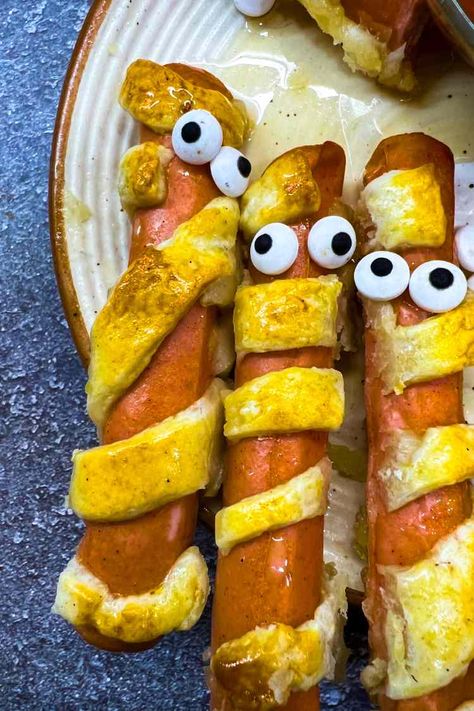 Halloween Mummy Hot Dogs - RecipeMagik Halloween Mummy Hot Dogs, Spooky Halloween Recipes, Chicken Recipes With Cream Cheese, Crescent Roll Pastry, Mummy Hot Dogs, Spooky Halloween Food, Halloween Food Appetizers, Halloween Drink, Halloween Food Treats