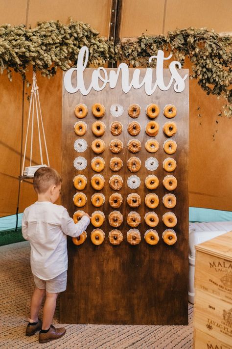 Doughnut Wall As Alternative Wedding Cake | By Storybox Films | Outdoor Wedding | Summer Wedding | Doughnut Wall | Alternative Wedding Cake | Tipi Wedding | Outdoor Ceremony | Macrame Wedding Decor | Lace Wedding Dress | Long Sleeve Wedding Dress | Grace Loves Lace Dress | Pale Suit For Groom | Foliage Bouquet | Foliage Crown | Flower Crown | Kids At Wedding | Wedding Nail | Wedding BBQ | Wedding Food | Grazing Table At Wedding | Birthday Party Dessert Table, Macrame Wedding Decor, Alternative Wedding Cakes, Dessert Table Sign, Donut Bar, Birthday Party Desserts, Party Dessert Table, Bbq Wedding, Macrame Wedding