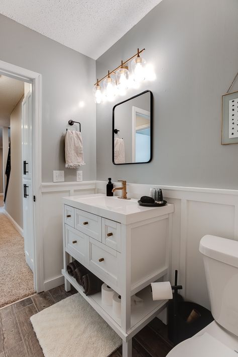 Small Half Bath White Vanity, Black Bathroom With White Wainscotting, Bathroom Remodel With Waynes Coating, Half Bathroom Wood Floor, White Bathroom Board And Batten, Half Bath With White Vanity, Half Bath With No Window, White Vanity Half Bath, Farmhouse Bathroom With Board And Batten