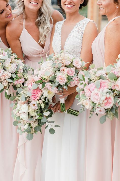 Bridal party in light pink dresses smiling and holding their wedding bouquets that have pink flowers and greenery. Light Pink Peony Wedding Bouquet, Light Pink And Greenery Wedding, Pink Flower Bouquet Bridesmaid, Light Pink And Green Wedding Flowers, Neutral Pink Wedding Flowers, Light Pink Wedding Bouquet With Greenery, Wedding Bouquets Light Pink, Pink Bridal Bouquet With Greenery, Wedding Flowers Light Pink