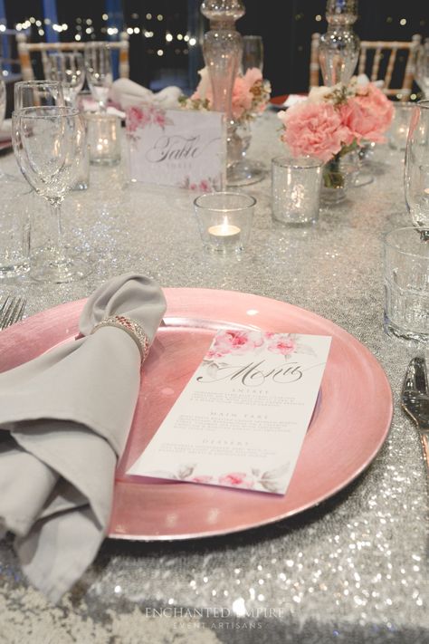 Set in a room of cascading fairylights, this romantic wedding style exuded class and elegance. An array of delicate pink hues were created throughout the centrepiece, to compliment our wedding stationery. Complete with pink watercolour, florals, menus and table numbers complimented the silver sequin cloths and silver mercury candle holders. Limewash Tiffany chairs brought this feminine theme together by adding an earthy element. Youtube: https://www.youtube.com/watch?v=SCevKsEAy7E Pink Silver Wedding Theme, Silver And Pink Wedding Theme, Pink And Silver Table Decor, Pink White Silver Table Decor, Pink And Silver Theme Party, Pink And Silver Wedding Decorations, Pink And Silver Quinceanera Theme, Pink And Silver Quinceanera Decorations, Pink And Silver Table Setting