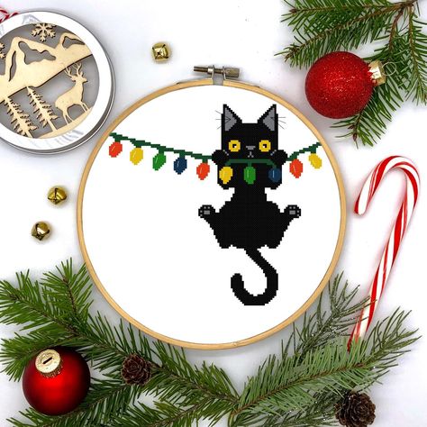 Christmas Holiday Black Cat Hanging from Lights Counted Cross Stitch Pattern Cross Stitch Calculator, Black Cat Cross Stitch, Cat Hanging, Holiday Cross Stitch, Cross Stitch Christmas Ornaments, Cat Holidays, Cat Cross Stitch, Christmas Embroidery, Christmas Cross