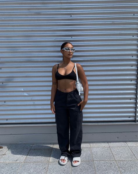 Black lightskin Girl wearing baggy black cargo pants with a black bralette top, a white mini bag, white slides and silver futuristic sunglasses. She’s wearing a sleek back ponytail and has flash art tattoos. Sporty Sunglasses, Sunglasses Outfit, Fashion Inspo, Street Wear, Sunglasses, Outfit Inspo, Silver