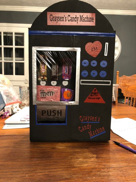 Made this with an Amazon box, black acrylic paint, foam board, Cricut, vinyl and of course candy. Candy Machine Diy Cardboard, Vending Machine Valentines Boxes, Valentine Box Claw Machine, Valentines Boxes For Kids School Vending Machine, Valentine’s Day Box Claw Machine, Candy Vending Machine, Diy Valentines Box, Kids Valentine Boxes, Valentine Card Box