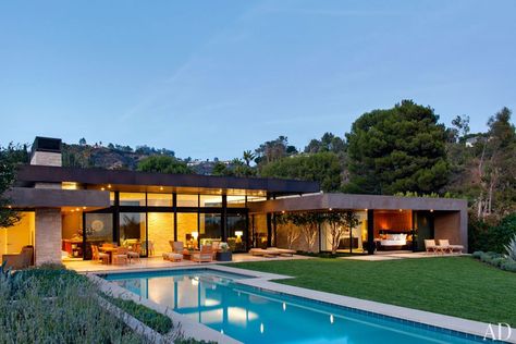 The house, which is tucked into a hillside to maximize space for the terraces, lawn, and glass-tiled pool, is marked by deep roof overhangs that provide shade and extend the architecture into the outdoors. Marmol Radziner, California Architecture, Pool House Designs, Flat Roof House, Beverly Hills Houses, Contemporary Exterior, Modern Flat, Modern Houses, New Home Builders