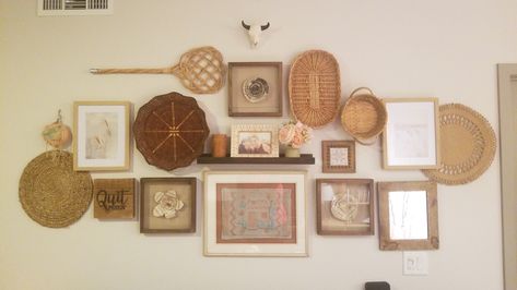 A messy-clean look involving wicker baskets, picture frames, and knick-knacks Baskets And Pictures On Wall, Baskets As Wall Decor, Basket And Picture Wall, Wall Baskets Around Picture, Boho Picture Frames On The Wall, Basket Wall With Picture Frames, Basket Wall With Picture, Gallery Wall With Baskets, Basket And Picture Gallery Wall