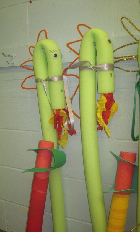 Dragon (character that runs throughout the curriculum) made out of pool noodles.  Use a rubber band to fold the noodle into a head.  Scales made using pipe cleaners.  Flames are crape paper.  The girls added eyelashes to their dragons.  Swords made out of half a pool noodle. Pool Noodle Dragon, Noodle Dragon, Castle Vbs, Dragon And Unicorn, Day Camp Activities, Rally Idea, Noodles Ideas, Reading Week, Dragon Character