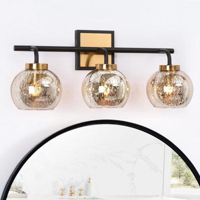 The highlight of this bathroom vanity light is the unique mercury glass shade. Whether you use white light or warm light, it will show very beautiful patterns when the light is turned on. The combination of black and vintage brass is suitable for a variety of styles such as modern, farmhouse, mid-century modern, etc. making your bathroom look with understated colors without being monotonous. Compatible with an E26 base and max 40W light bulbs, this modern wall light will bring sufficient lightin Black Gold Bathroom, Gold Bathroom Vanity, Farmhouse Vanity Lights, Glass Light Fixtures, Bathroom Vanity Lights, Modern Bathroom Vanity Lighting, Black And Gold Bathroom, Brass Vanity Light, Modern Vanity Lighting