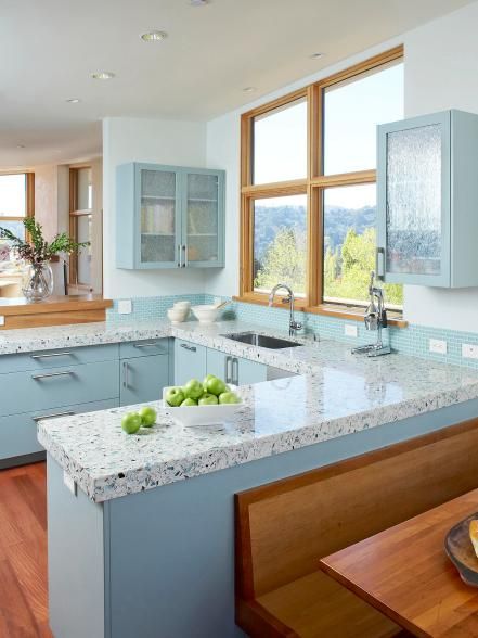 The eco-friendly choice, recycled countertops come in a variety of sustainable materials, including concrete, glass, paper, composite and plastic. Usually a mix of pre- and post-consumer products, recycled countertops are available in a wide range of colors and textures. This beachy kitchen by Massucco Warner Miller features IceStone terrazzo which is composed of recycled glass, Portland cement and resin for a durable, low-maintenance surface. Blue Countertops, Hgtv Kitchens, Coastal Kitchen Design, Outdoor Kitchen Countertops, Kitchen Design Color, Kabinet Dapur, Kitchen Countertop Materials, Kitchen Glass, Casa Vintage