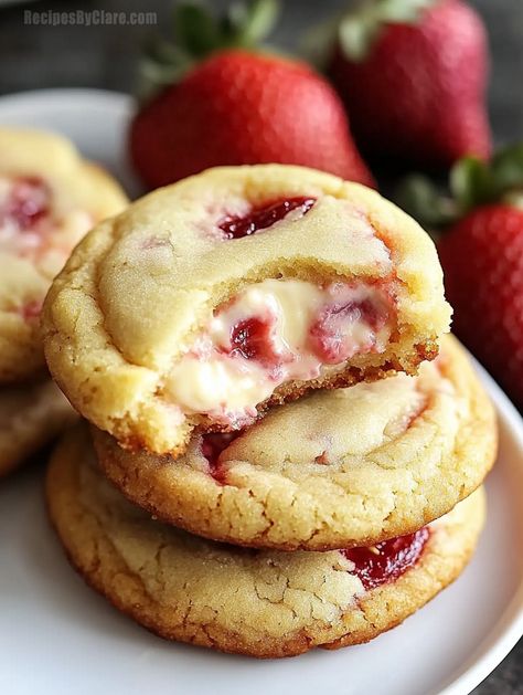 Soft and fruity cookies with a surprise creamy strawberry cheesecake center. Perfect for any sweet tooth craving! Thumbprint Cookies Strawberry, Cranberry Cheesecake Cookies, Strawberry Cheesecake Cookie Recipe, Cheesecake Stuffed Cookies Recipes, Cream Cheese Churro Cookies, Fruit Filled Cookies, Strawberry Cheesecake Cookie Bars, Strawberry Cheesecake Stuffed Cookies, Freeze Dried Strawberry Cookies