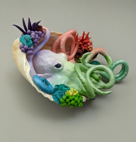 Handmade polymer sculpture.  This pastel octopus sits in a shell surrounded by corals and anemones.  While this sculpture has been baked and is relatively strong, it can break if handled roughly or dropped. Unique Sculptures Creative, Sea Shell Sculpture, Polymer Clay Bead Ideas, Oven Dry Clay Projects, Clay Projects For High School, Things To Do With Shells, Polymer Clay Sculpture Ideas, Animal Sculptures Clay, Clay Modelling Ideas