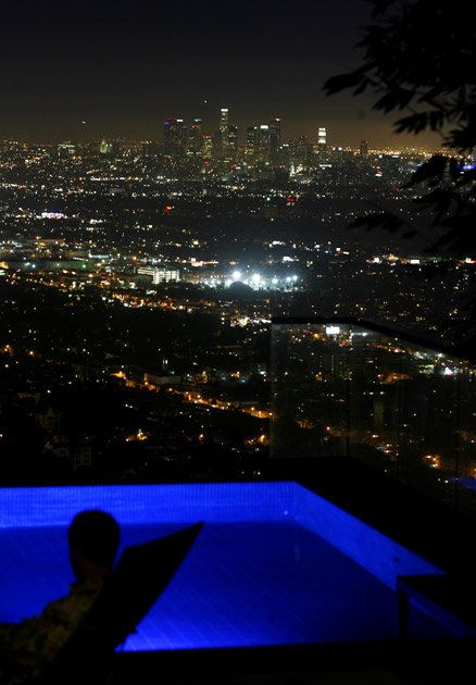 The pool is suspended atop a 40-foot-long platform beneath which is an enclosed screening room with a downtown skyline view. Hollywood Hills View, Nights Like This, Hollywood Hills Aesthetic, California Pool, Hillside Pool, House In The Hills, Business Tycoon, Architecture Unique, Spoiled Brat