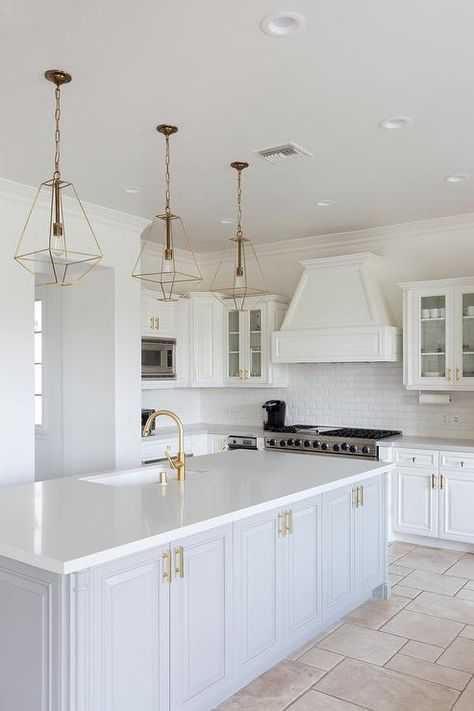 Three gold lanterns hang over a light gray island accented with brass pulls and a white quartz countertop fitted with an undermount sink with a brass gooseneck faucet. Home Remodel Before And After, Gray And White Kitchen, Kitchen Farmhouse, Kitchen Lighting Fixtures, Grey Kitchen, Trendy Kitchen, California Homes, Kitchen Remodel Idea, White Cabinets