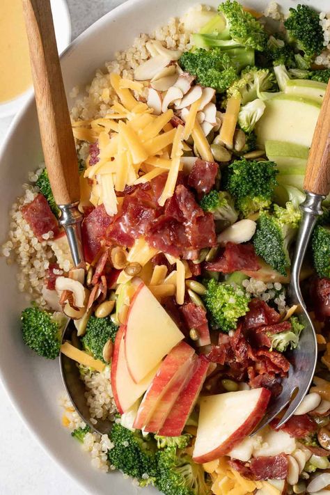 This Broccoli Cheddar Quinoa Salad recipe is a delicious mix of quinoa, broccoli, cheddar cheese, apples, nuts and seeds, and its all tossed in a deliciously addictive maple vinaigrette. Apple Cheddar Broccoli Quinoa Salad, Apple Cheddar Quinoa Salad, Winter Quinoa Recipes, Apple Cheddar Salad, Broccoli Cheddar Quinoa, Quinoa Salad Dressing, Cheese Apples, Southwest Quinoa Salad, Quinoa Broccoli