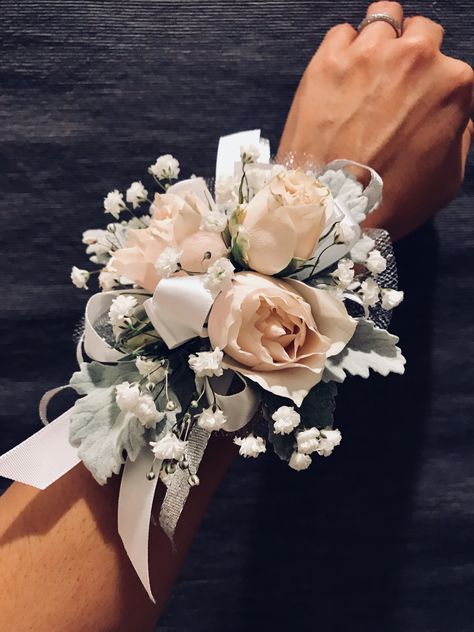 Ladies wristband corsage featuring spray roses, dusty miller and baby’s breath. Accented with silver mesh tulle, white satin and silver ribbons. Gold Corsage, Prom Flowers Corsage, White Corsage, Wrist Corsage Wedding, Wrist Corsage Prom, Prom Corsage And Boutonniere, Homecoming Corsage, Boutonnieres Prom, Corsage And Boutonniere Set