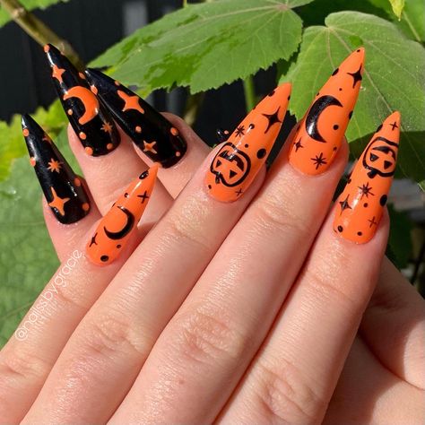 Long stiletto nails, one hand orange with black stars, moons and Jack o lanterns painted on, other hand black with orange stars and moons against a leaf background October Makeup, Halloween Nail Art Easy, Nail Art Halloween, Holloween Nails, Halloween Nails Easy, Halloween Acrylic Nails, Cute Halloween Nails, Spooky Art, Halloween Nail Designs