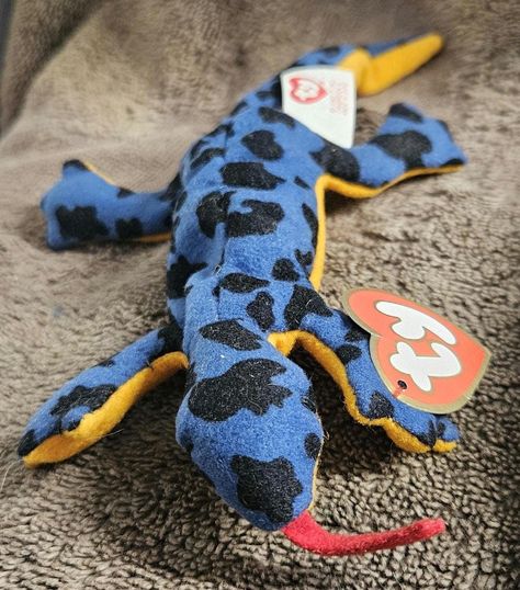 This Ty Beanie Babies Lizz McDonald's Teenie Lizard Reptile Plush is a cute and cuddly addition to any child's collection. The plush toy is made of soft, plush material that is gentle on your child's skin. The lizard is a great size for little hands to hold and carry around. This plush toy is sure to please any child. This plush toy is perfect for your child to take on a trip. It is small enough to fit in a suitcase or backpack, and it is lightweight enough for your child to carry. This plush to The Lizard, Ty Beanie Babies, Beanie Babies, Beanie Baby, Ty Beanie, Baby Beanie, Reptiles, Stuffed Animals, Soft Plush