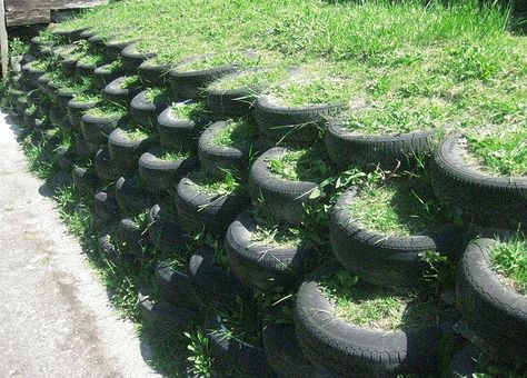 Tire retaining wall. All it needs is some plants and it would look super Tire Retaining Wall, Cheap Retaining Wall, Gabion Retaining Wall, Tire Garden, Tire Planters, Earthship Home, Landscaping Retaining Walls, Tyres Recycle, Old Tires