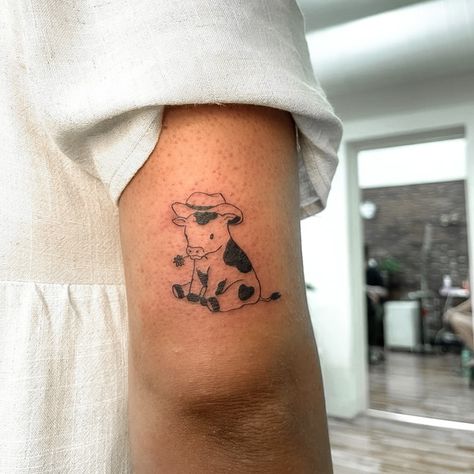 Cow Sitting Down Tattoo, Cow In Cowboy Hat Tattoo, Cow With Hat Tattoo, Cow Tattoo Small Cute, Cow Tattoo Aesthetic, Cow With A Cowboy Hat Tattoo, Cowboy Arm Tattoos, Cow With Cowboy Hat Drawing, Cow Inspired Tattoo