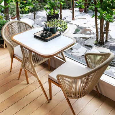 With storage layer, beautiful and practical Color: Cream Frame/White Table Top | Corrigan Studio® Krissia Rectangular 2 - Person 31.5" Long Bistro Set Stone / Concrete / Wicker / Rattan in White / Brown | 31.5 W x 22.44 D in | Outdoor Furniture | Wayfair Japandi Home, Bistro Table Outdoor, Stone Concrete, Patio Bar Set, Rattan Table, Outdoor Bistro Set, White Table Top, Dining Sets, Bistro Set