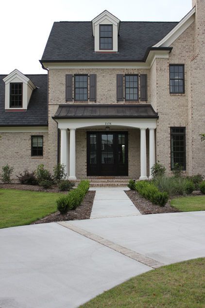 Amazing front door area. Walnut-colored operable composite raised-panel shutters look beautiful with this home's dark brown windows and washed and aged tumbled-brick exterior. Garage Colors, Roof Cladding, Black Shutters, Light Brick, Vinyl Wood, Brown Brick, Black Front Doors, House Trim, Front Porch Design