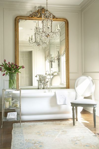 I love the designer’s use of an over-sized mirror leaning up against the wall behind this freestanding bathtub. Not only does it help to reflect light around the room, but it creates a dramatic focal point since there is no window above the tub. See more French Country Style Bathroom, Parisian Bathroom, Country Style Bathrooms, French Country Rug, Country Bathroom Decor, French Bathroom, Romantic Interior, French Country Bathroom, Modern French Country