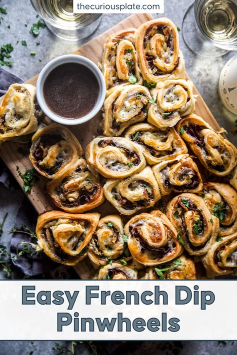 These Easy French Dip Pinwheels are made of layers of deli roast beef, melty provolone cheese, and sweet caramelized onions rolled in buttery dough and baked to crisp, golden goodness! It comes with homemade au jus, a French savory beef gravy to dip the yummy pinwheels into. These easy and delicious morsels make the perfect party appetizers or all-day snacks for the family. Pop over to my site for the recipe! | appetizers | easy snacks | pinwheel appetizers | What To Serve At A Party, French Dip Roll Ups, Football Hors D’oeuvres, Best Meat Appetizers, Beef Appetizers Fancy, French Appetizers Party Finger Foods, Appetizer With Meat, French Dip Rolls, Beef Crostini Appetizers