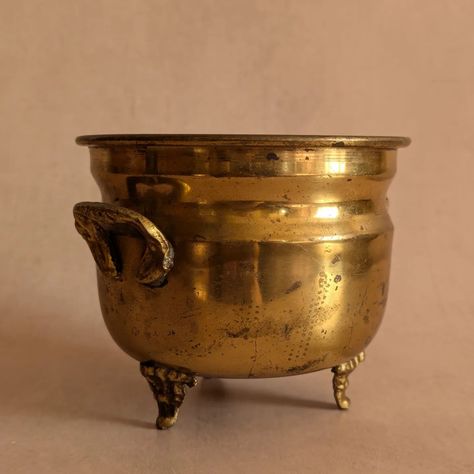 ✨Vintage Brass Cauldron Twin-Handled Footed Planter Pot✨ 🎃 A handsome brass cauldron planter with double handles and the sweetest little feet 🎃 A perfect piece to add to your Halloween decor but certainly versatile enough to keep out all year-round 🎃 Would look beautiful at Christmas as well! 🎃 Vintage c. 1960s 💸 price and more details/photos on website 🇬🇧 FREE UK p+p #halloweenhomedecor #halloweendecoration #witchyhome #witchydecor #witchaesthetic #witchyhomedecor #paganwitch #cauldron Cauldron Aesthetic, Cauldron Planter, W.i.t.c.h Aesthetic, Witchy Home Decor, Interior Vintage, Pagan Witch, Witchy Decor, Halloween Home Decor, Home Accessory