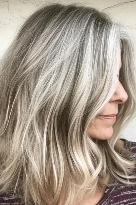 Sandy blonde is a light, muted shade that blends beautifully with gray hair, creating a soft, beachy look. Use a gentle, nourishing shampoo to keep it looking fresh. Click here to check out more where experts and women agree that these colors are perfect or gray hair. Fall Gray Blonde Hair Color, Ash Blonde And Gray Hair, Blonde Babylights To Blend Grey, Gray Hair Highlighted Blonde, Low Lights On White Grey Hair, Blond Grey Hair Going Gray, Blond Highlights On Greying Hair, Blending Greys Into Brown Hair Blonde, Light Brown With Silver Highlights